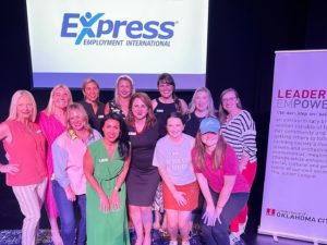 Board Members pose on stage under Express logo